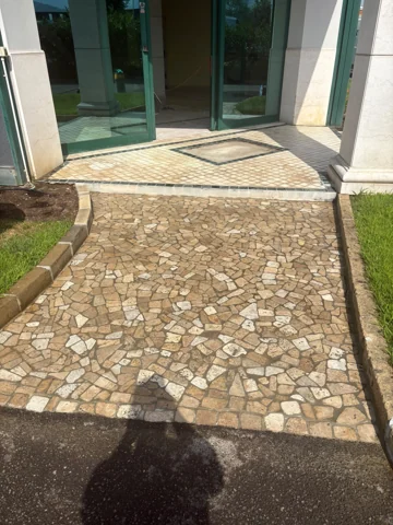 Vialetto di ingresso con pavimentazione in pietra davanti a una porta