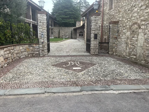 Cortile esterno con pavimentazione decorativa in pietra e ciottoli